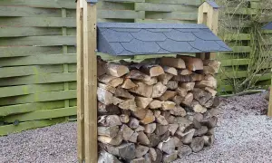 En stapel ved, redo för att bygga vedbod. Träet är torrt och fint staplat under ett tak.