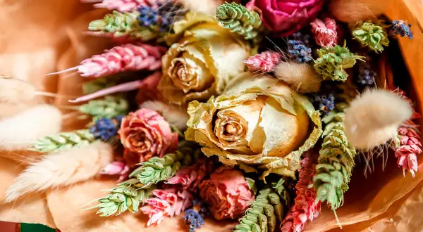 Vacker bukett med torkade rosor, lavendel och andra torkade blommor i varma färger.