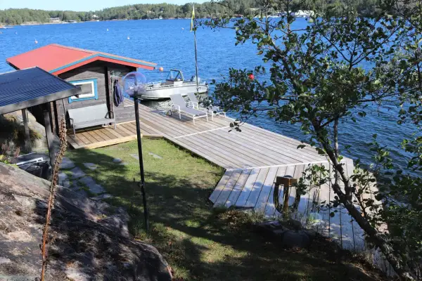 En nybyggd brygga med en liten stuga och båt. Perfekt för att bygga brygga och njuta av sommaren vid vattnet.